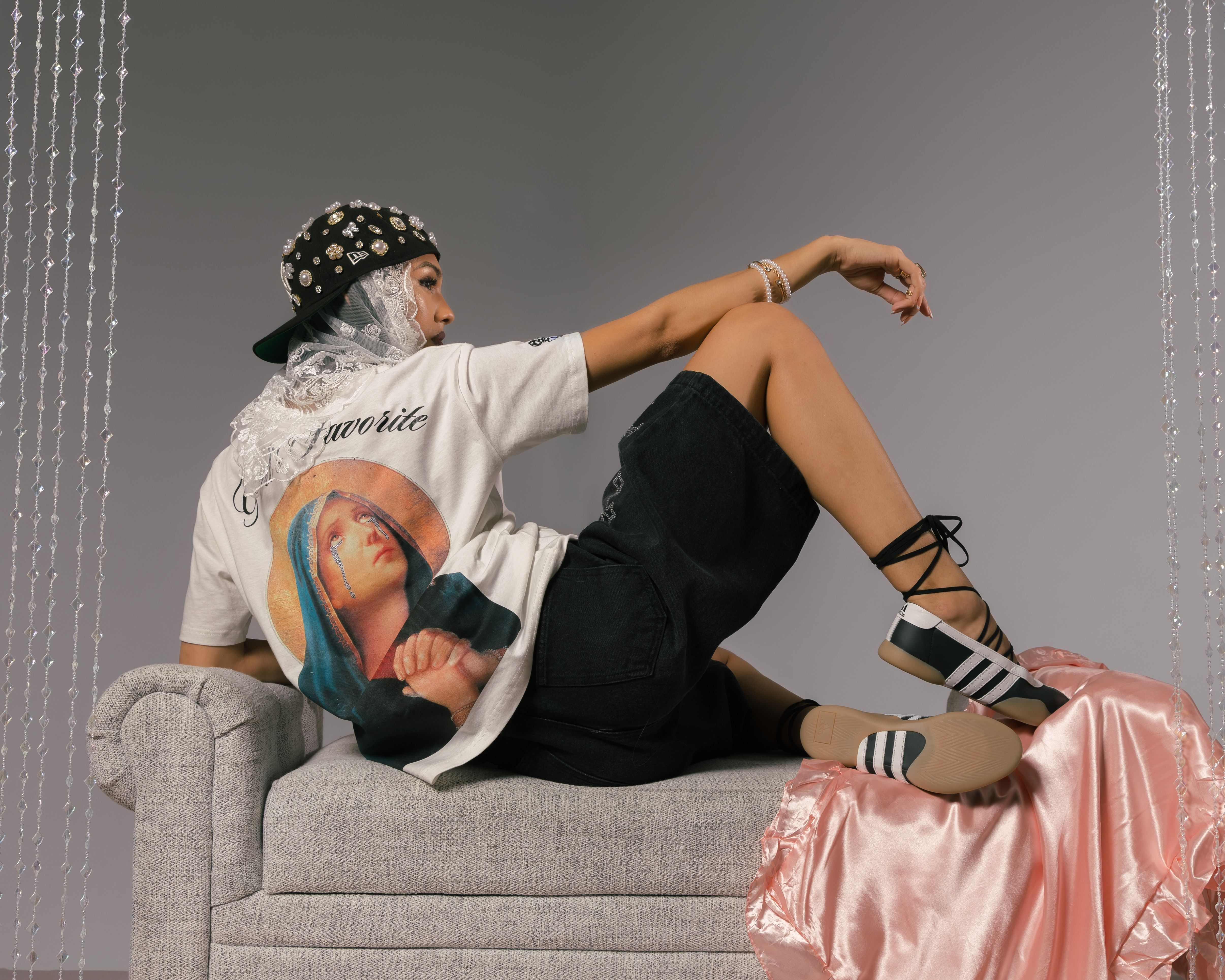 Person lounging on a couch, wearing a graphic t-shirt and stylish footwear.