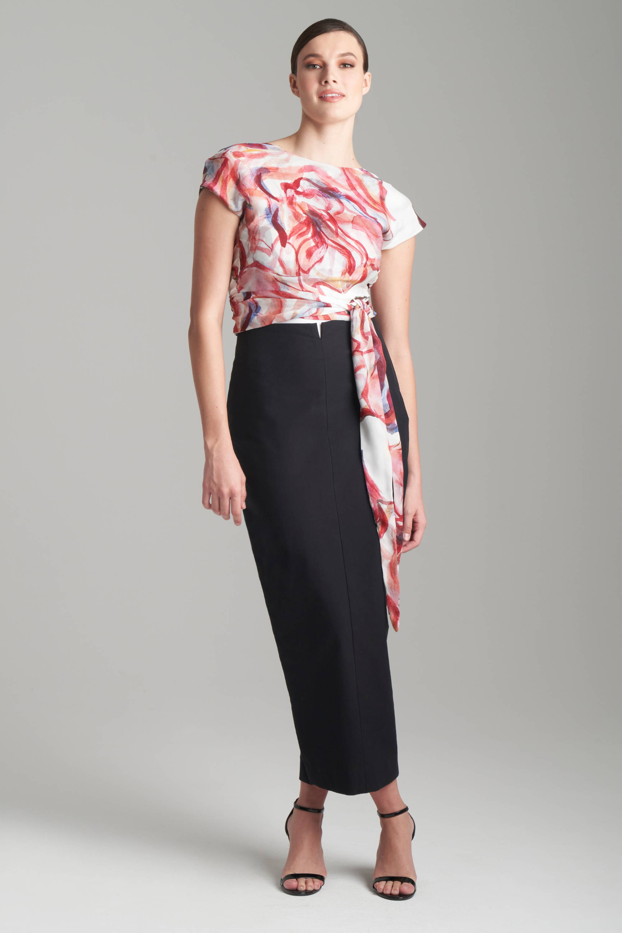 Woman wearing red and whtie rose printed reversible slk wrap top wth black pencil skirt by Ala von Auersperg