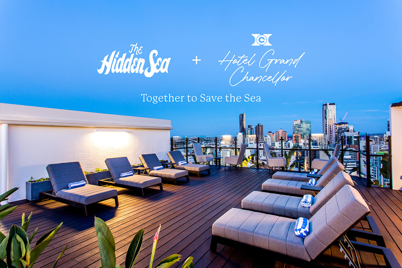 Rooftop terrace at Hotel Grand Chancellor overlooking the city skyline, featuring The Hidden Sea and Hotel Grand Chancellor logos with the message “Together to Save the Sea.”