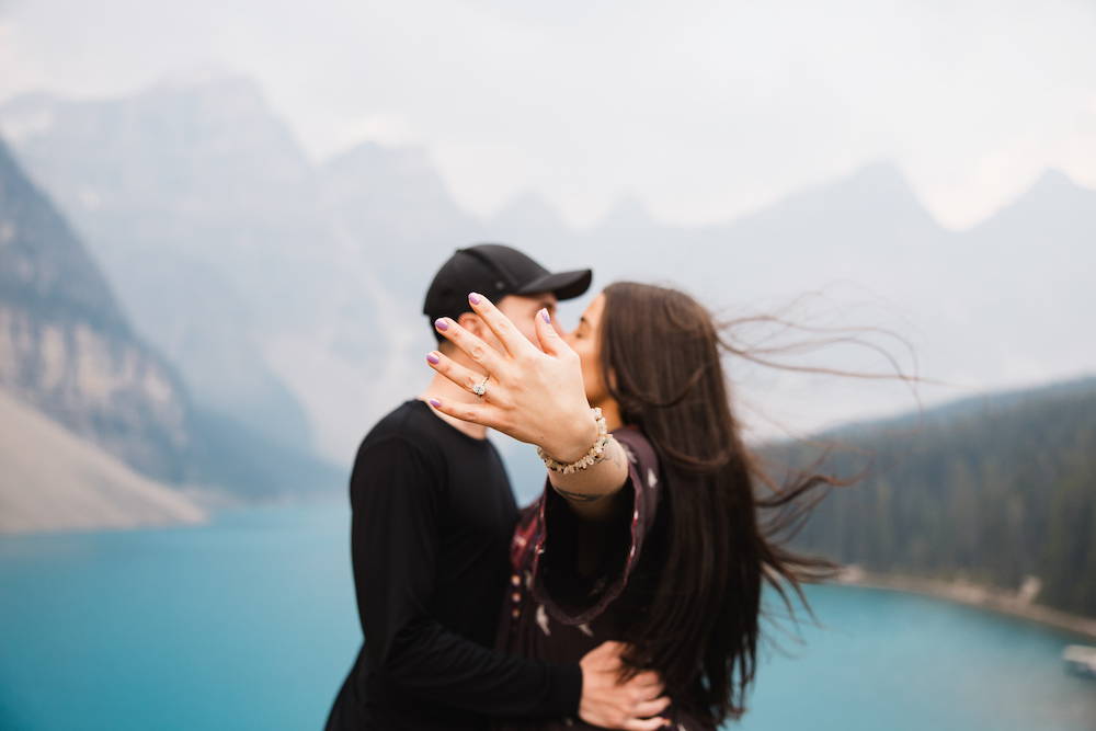engaged couple with lake moraine in background