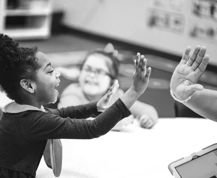 Niñas aprendiendo cosas nuevas en la escuela en un dispositivo Tobii Dynavox de CAA.