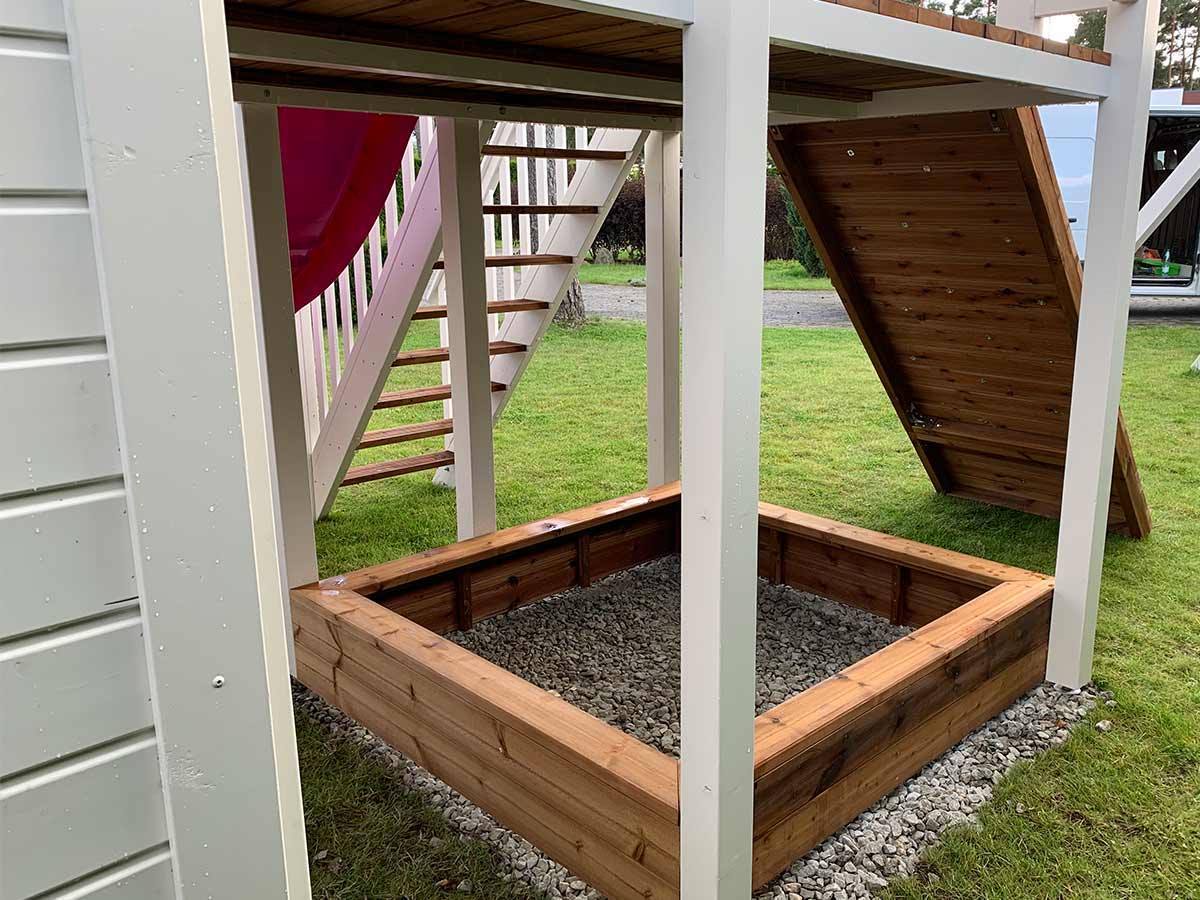 Close up of sandbox under the balcony of 2- story Wooden Playhouse Princess by WholeWoodPlayhouses