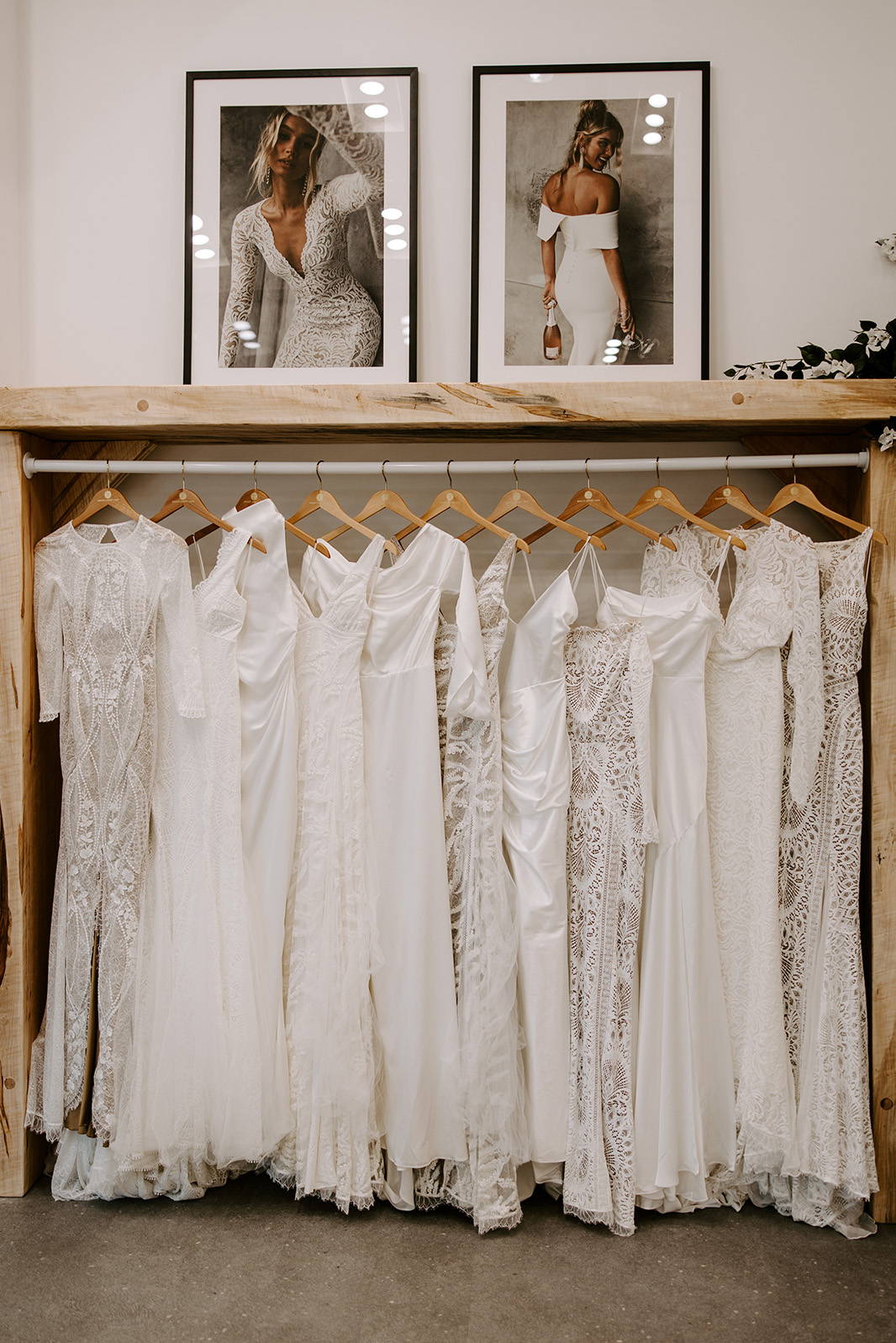 Grace Loves Lace wedding gowns hanging on wooden hangers