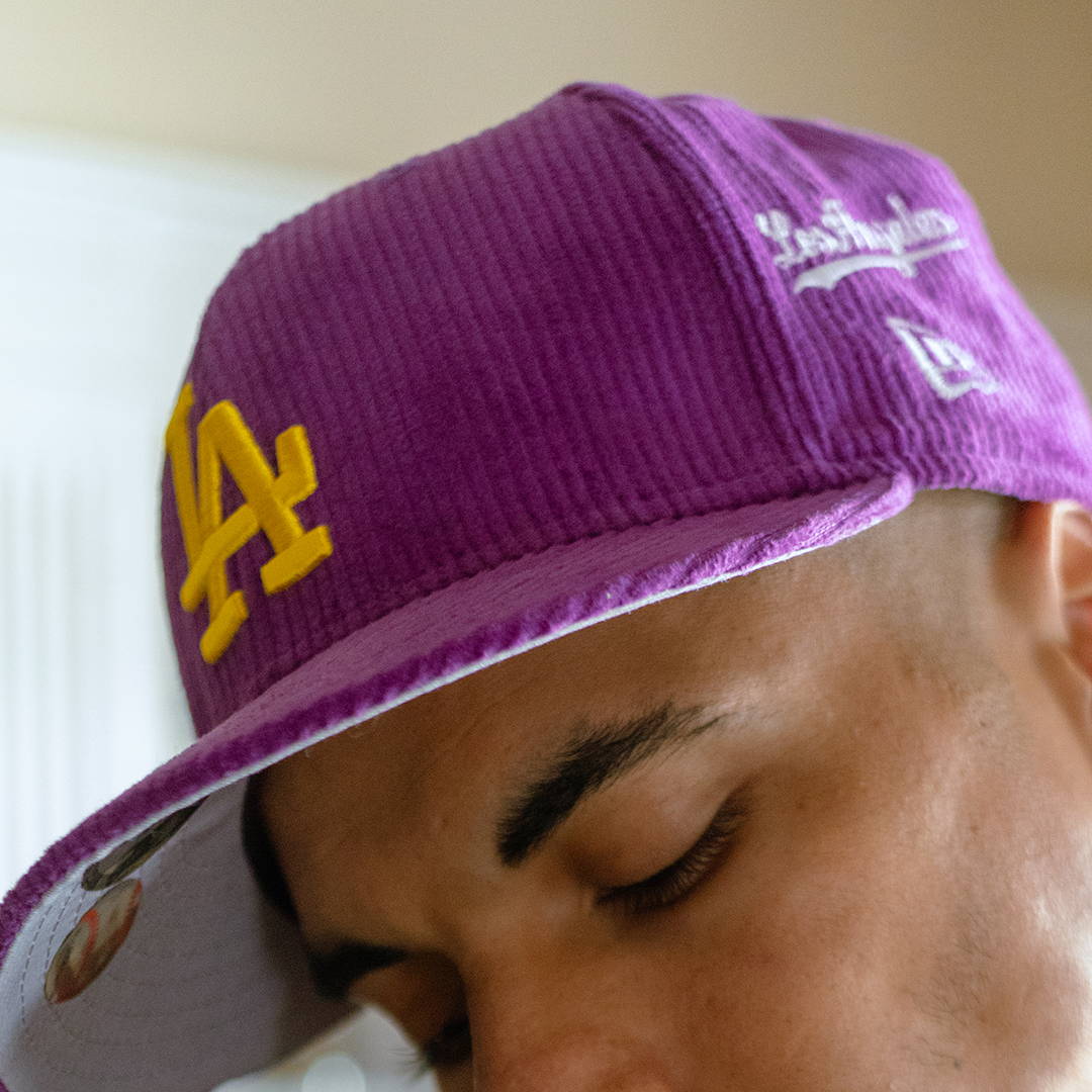 man wearing purple dodgers hat
