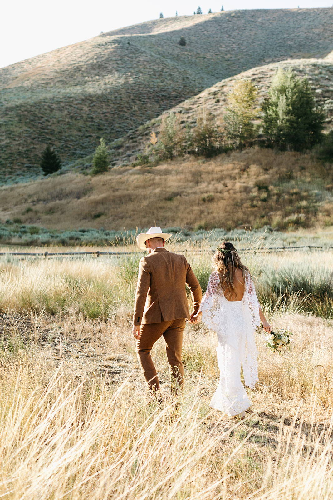 Bride and groom holding hands in paddock