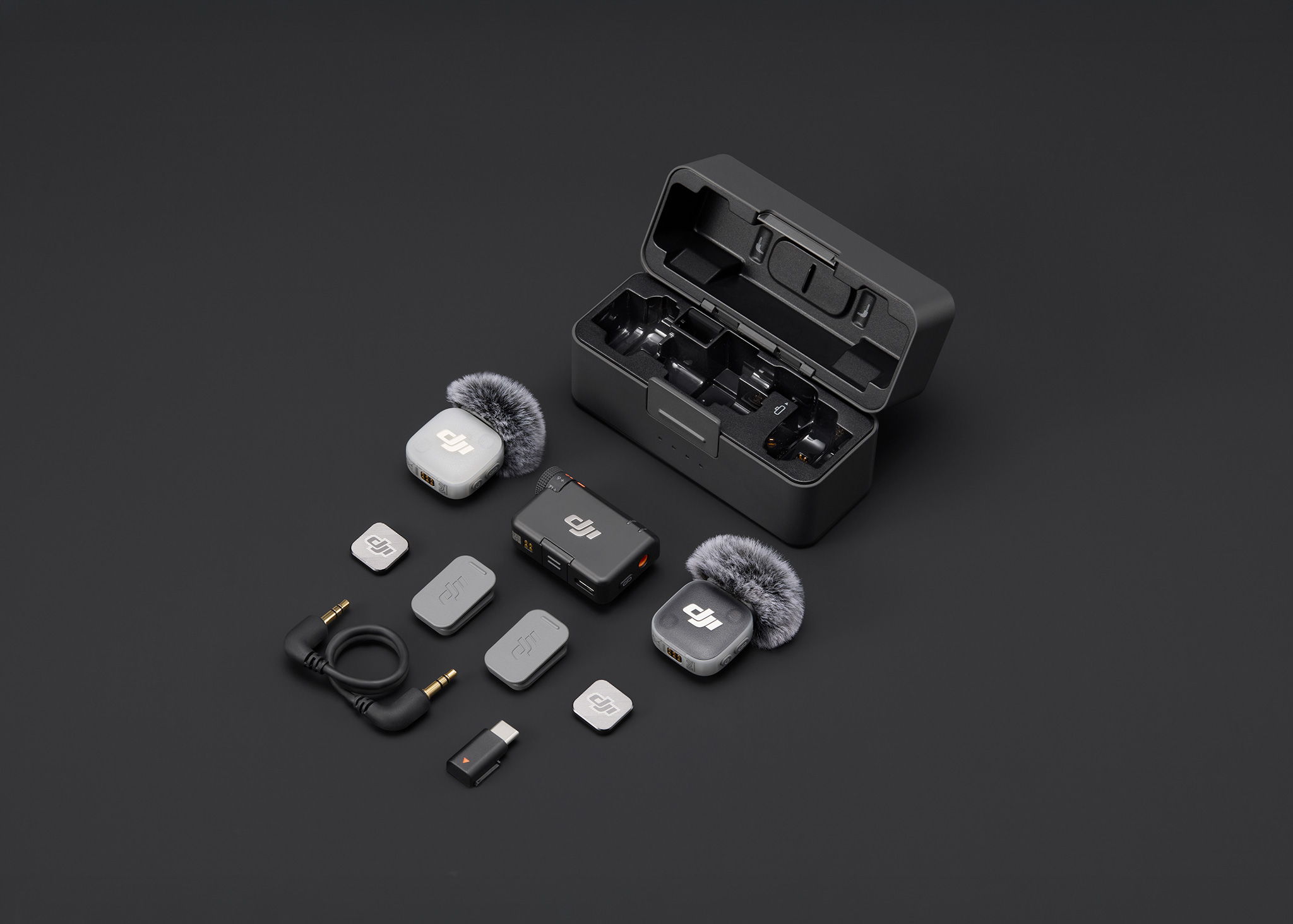 DJI Mic Mini 2 and accessories arranged together on a dark surface