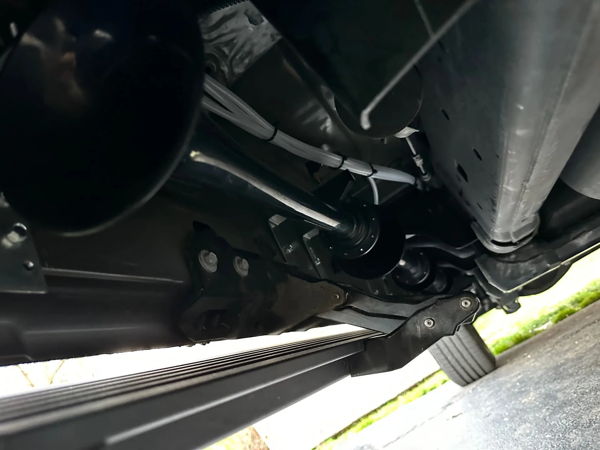 Undercarriage view of HornBlasters train horn with black bell, chrome trumpet, and white air lines
