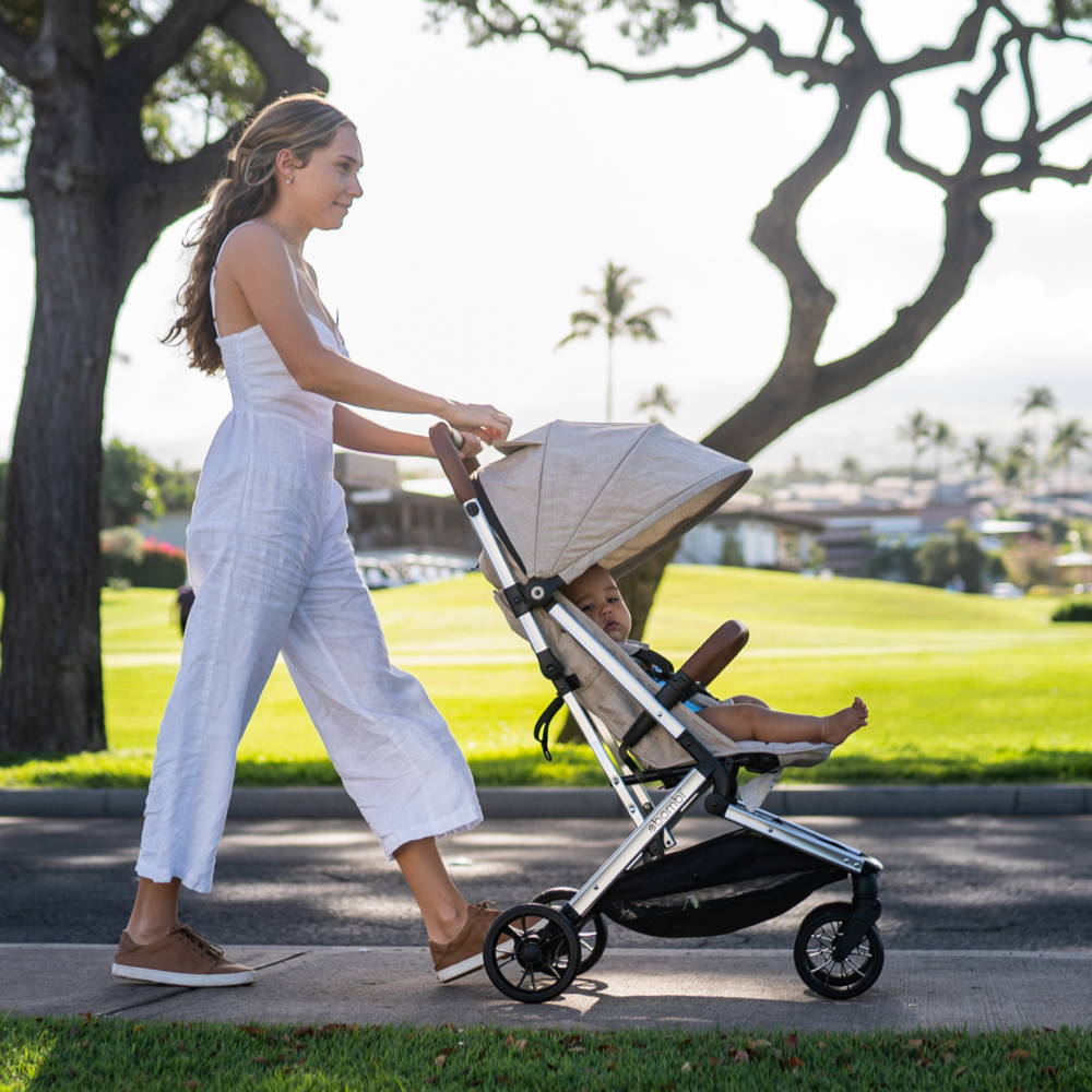 Mother pushing her baby in a Bebee stroller in a beautiful park
