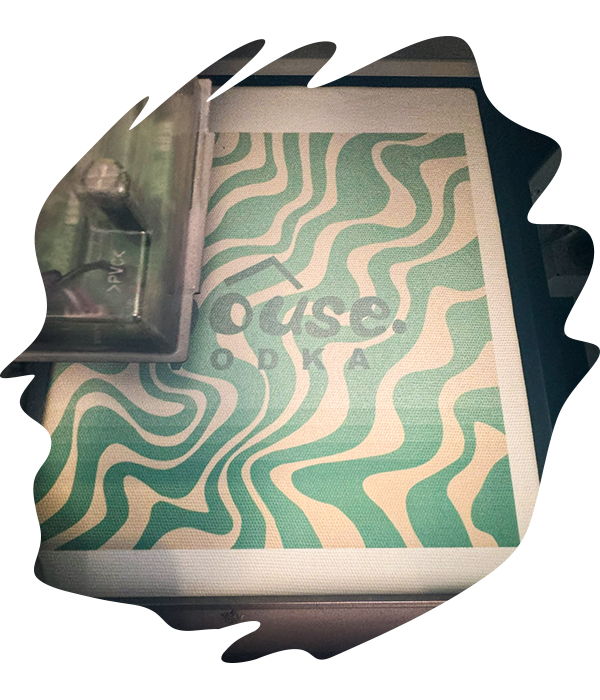 DTG printer applying a psychedlic green patterned design onto fabric with precise ink layering visible on the platen.