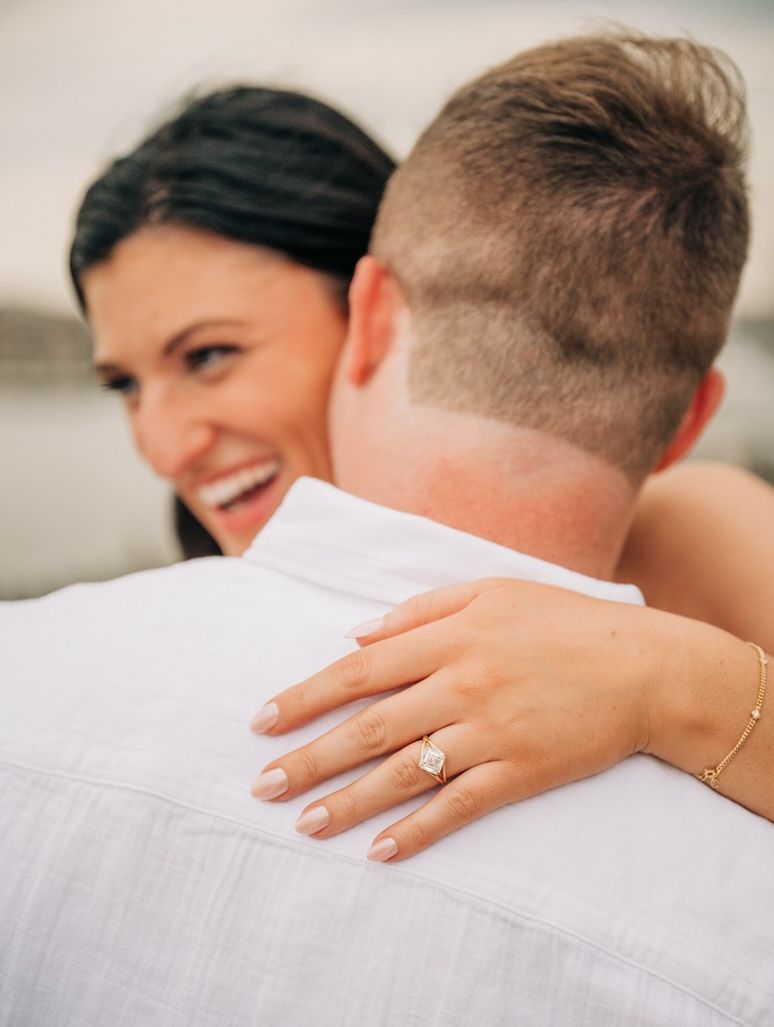 engaged couple embracing with diamond ring