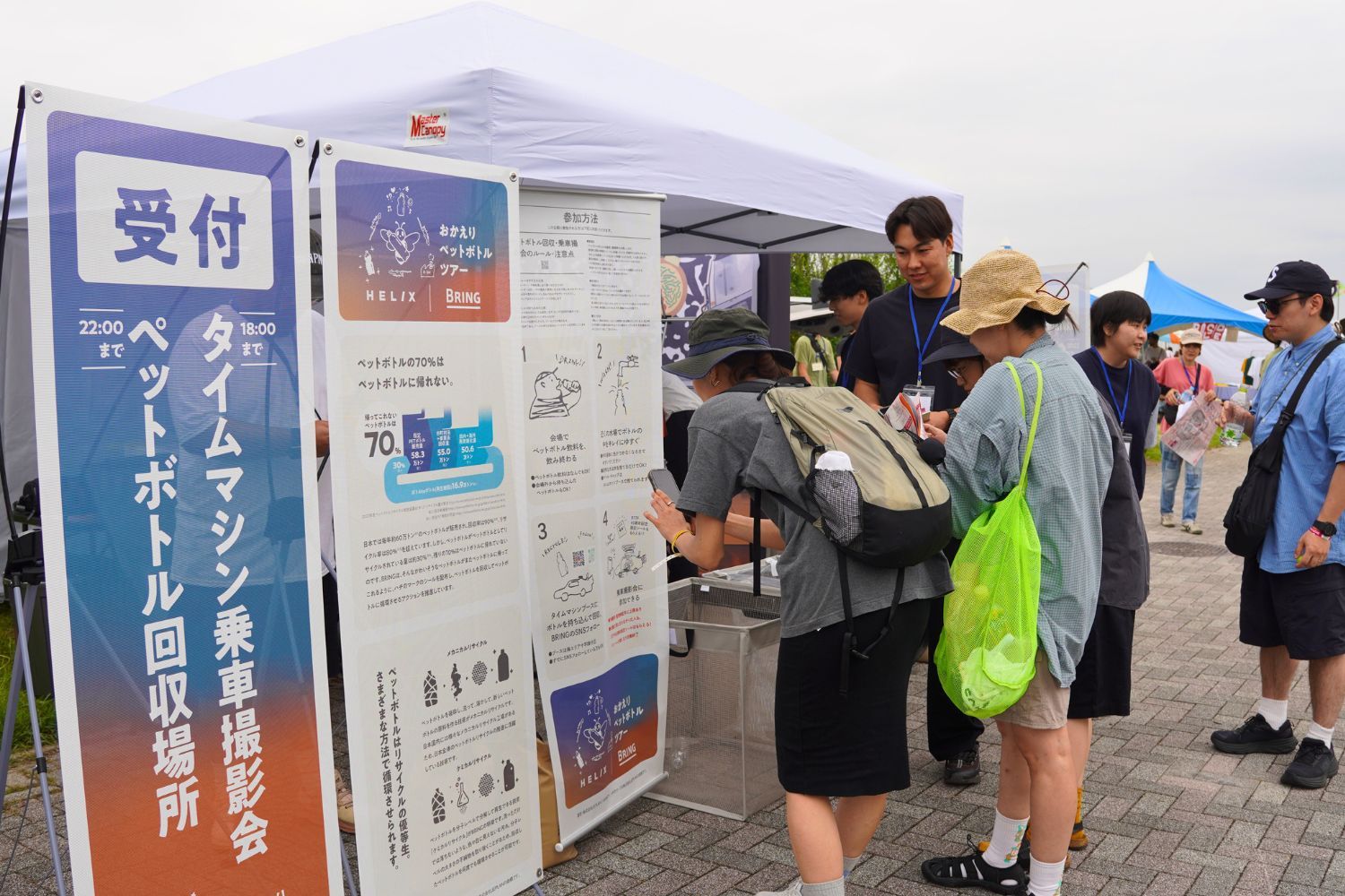 People at a booth reading information and registering for an event.