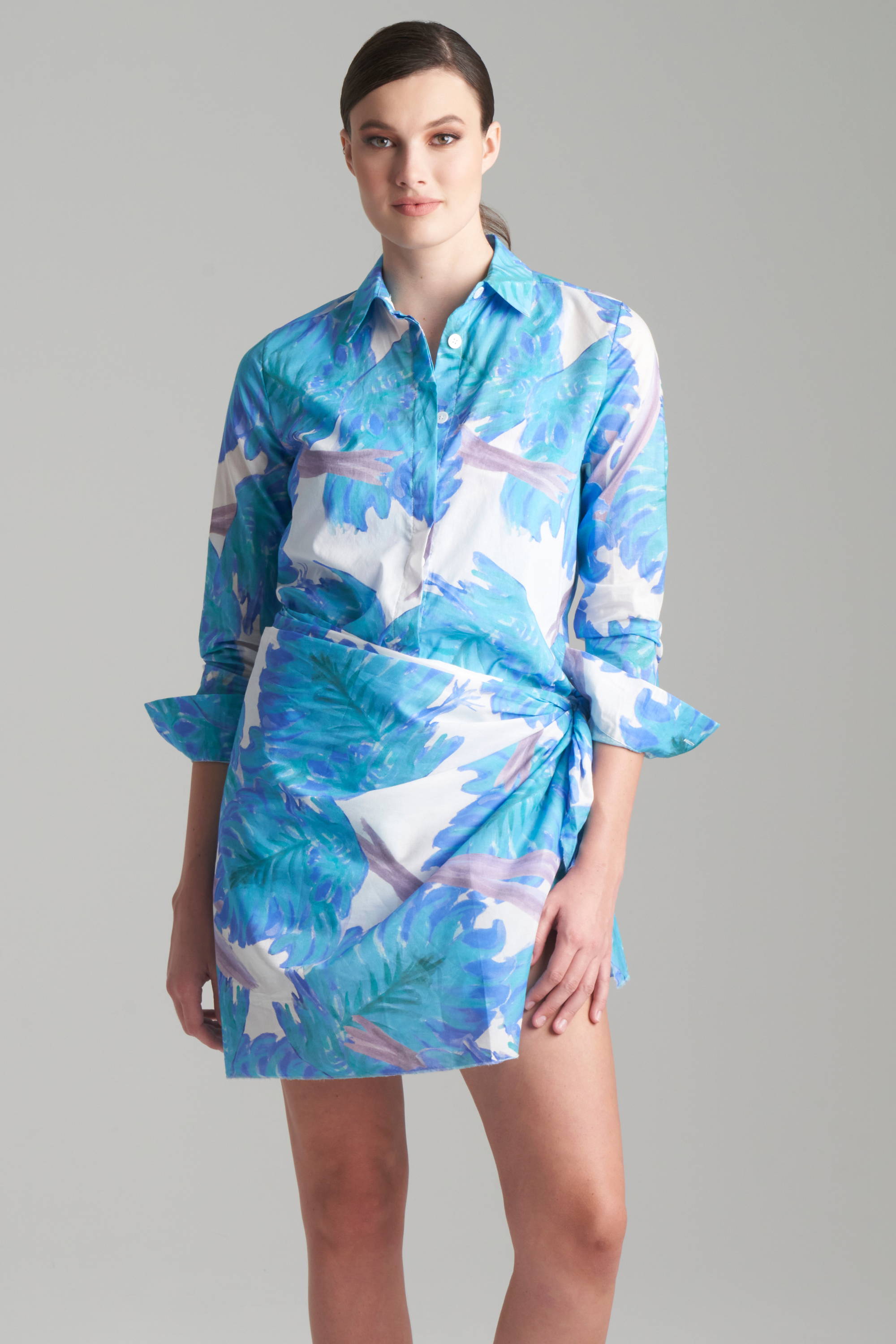 Woman wearing blue cotton floral shirt with matching cotton wrap over a one piece bathing suit by Ala von Auersperg and Cover Swim