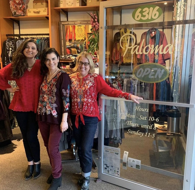 Paloma Clothing  owner Kim and employees in front of store door.