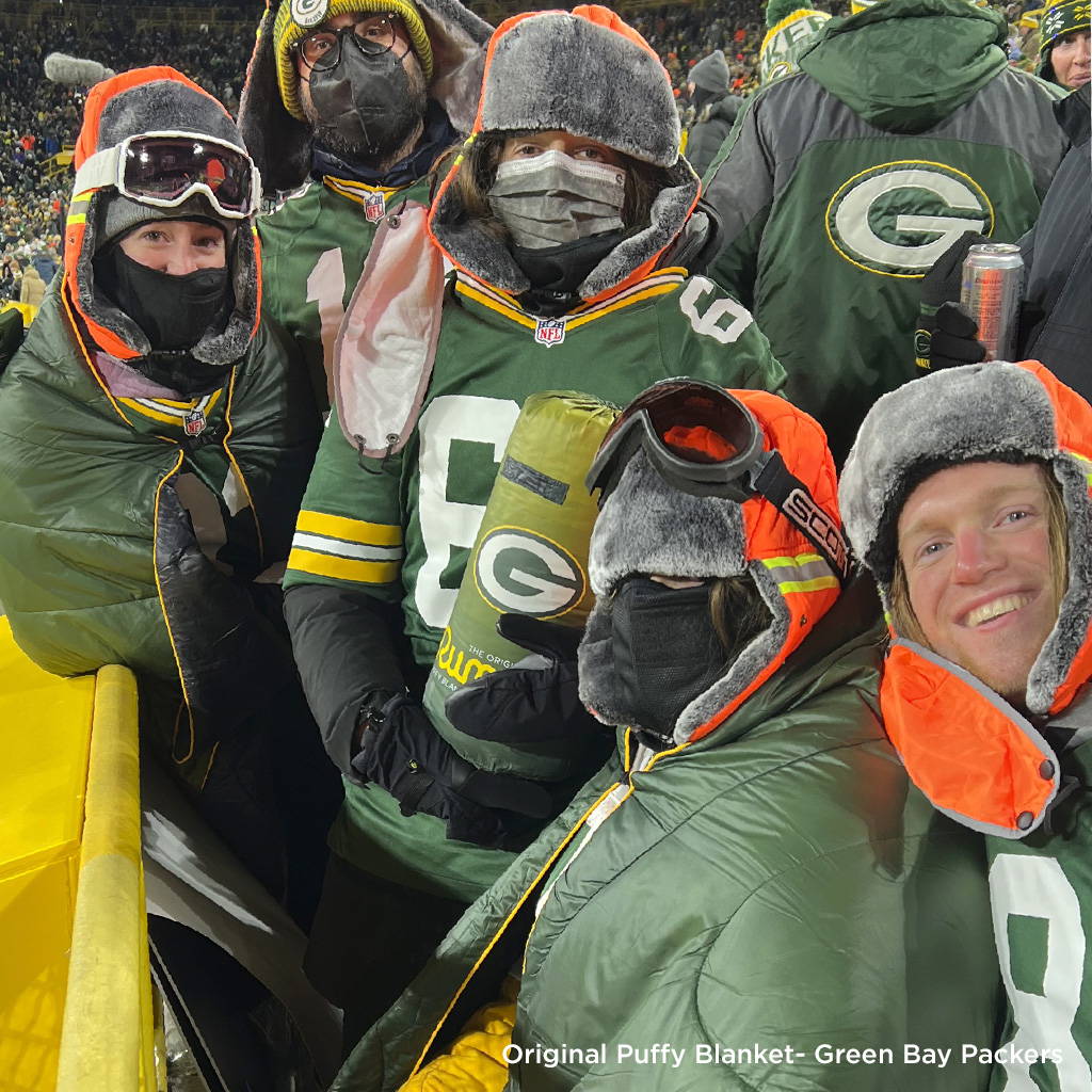 People wearing Green Bay Packers Rumpl blanket at game in stadium