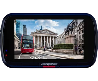 A red bus passes a historic building in an urban setting.