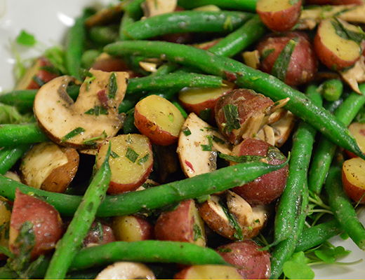 A colorful salad of green beans and red potatoes.
