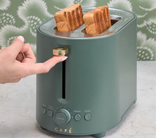 A hand pressing the lever of a green toaster with two slices of toast.