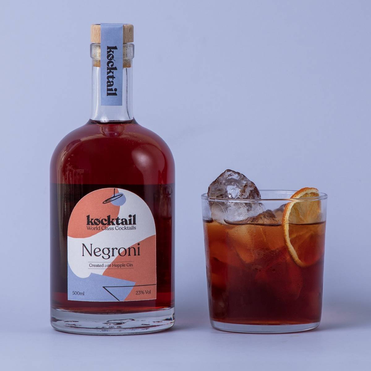 Negroni bottle and cocktail on blue background