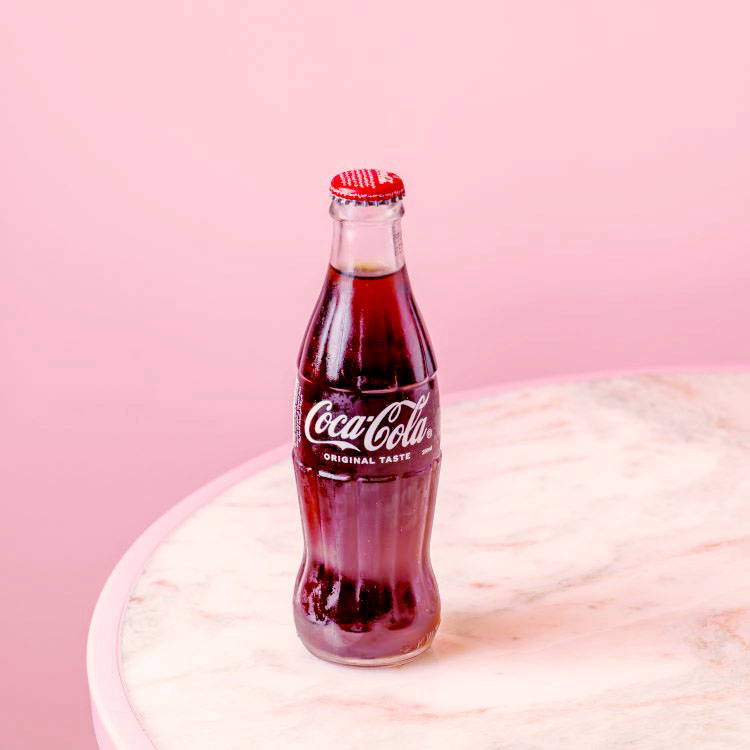 Coke in glass bottle on marble table