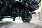Low-angle four black train horns rear axle teal suspension off-road tires undercarriage Kealoha's 244K Spare Tire Delete install gallery photo 2