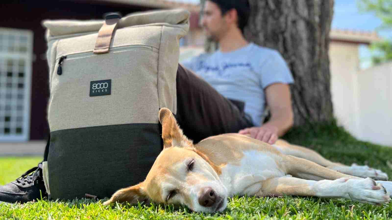 A man and dog rest near a hemp backpack