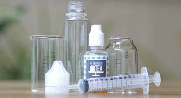 Bottles, one shot concentrate, syringe on a table