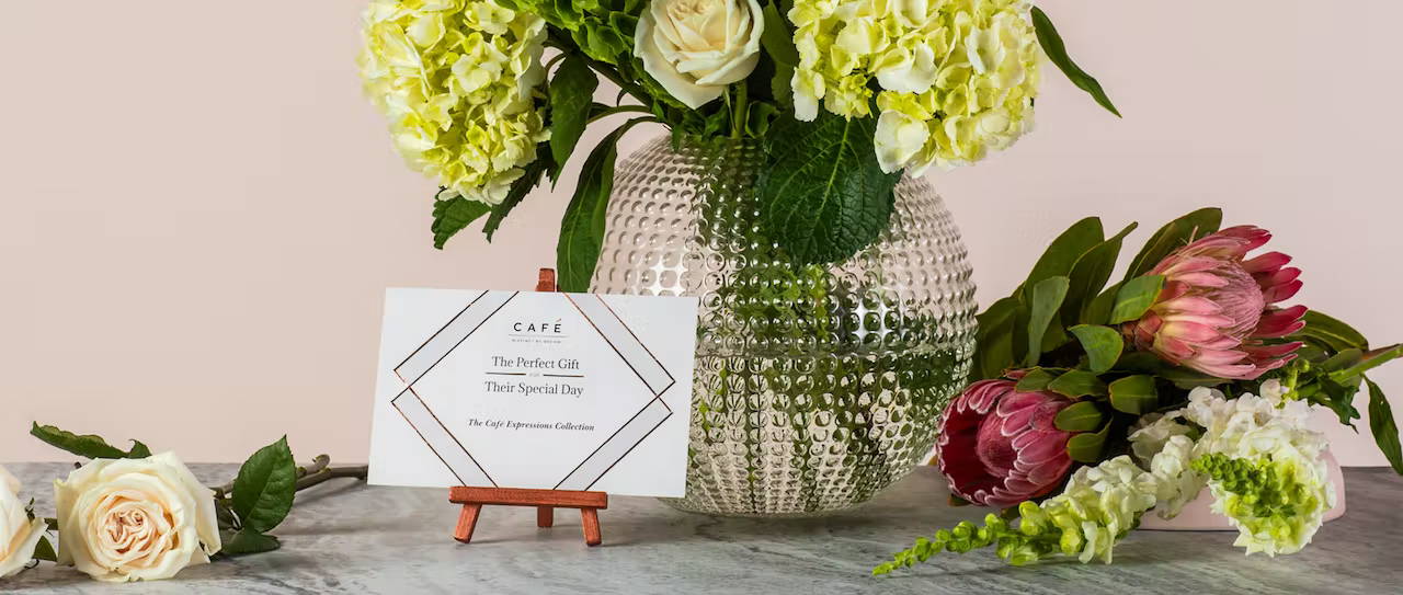 Wedding invite on table surrounded by flowers