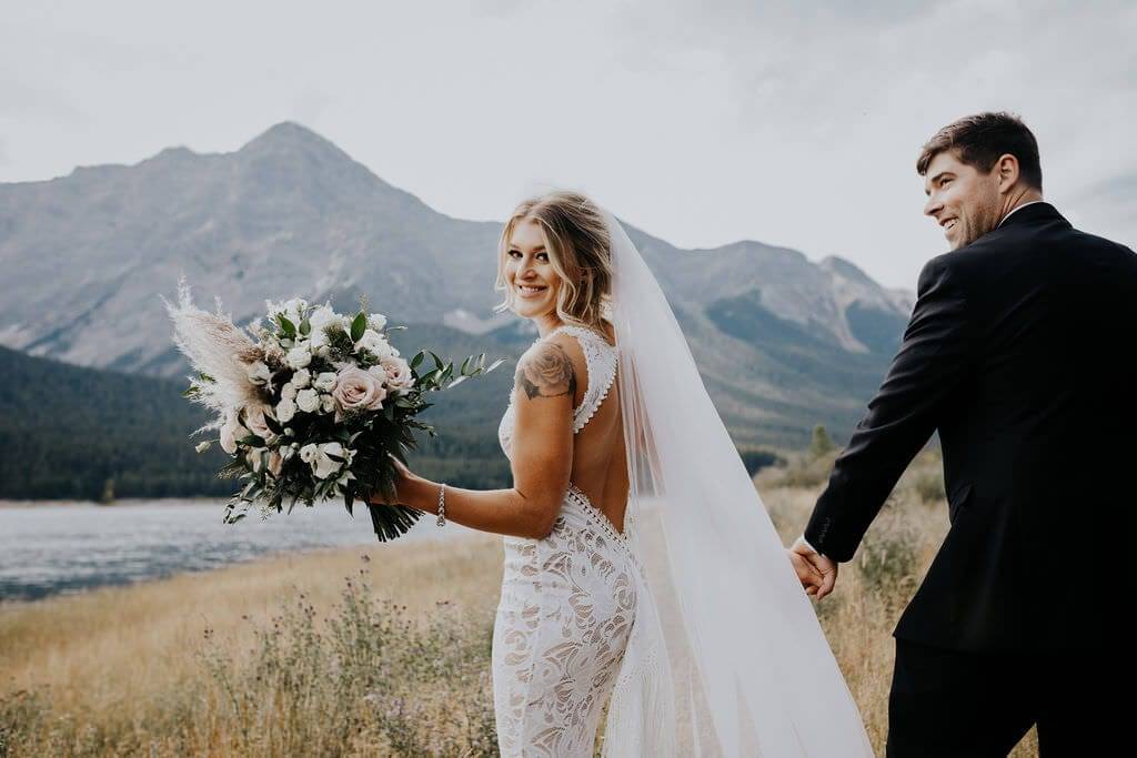 Grace bride in the Edie wedding dress with her groom in Canmore Alberta