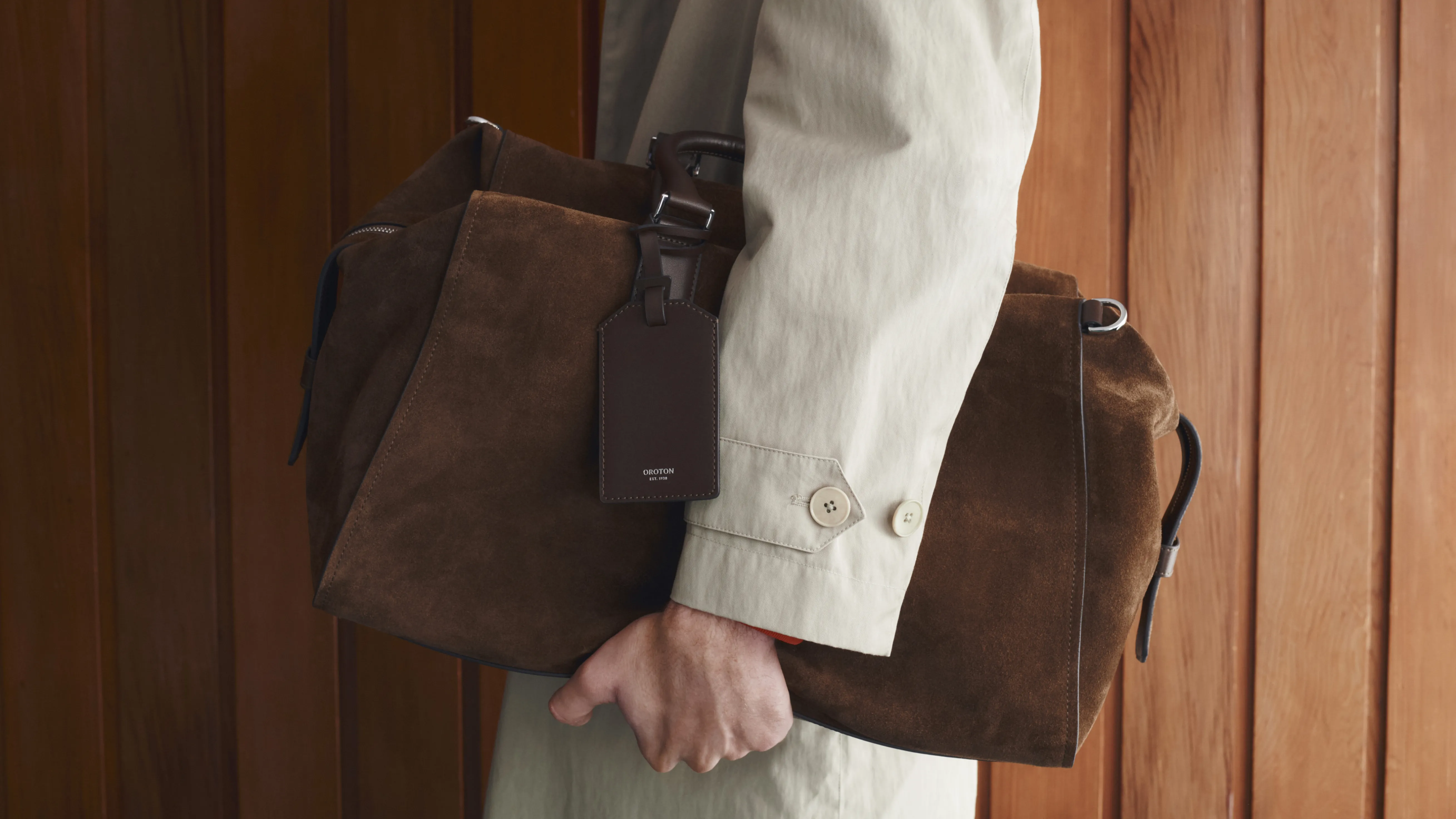 A person holding a brown bag against a wooden background.