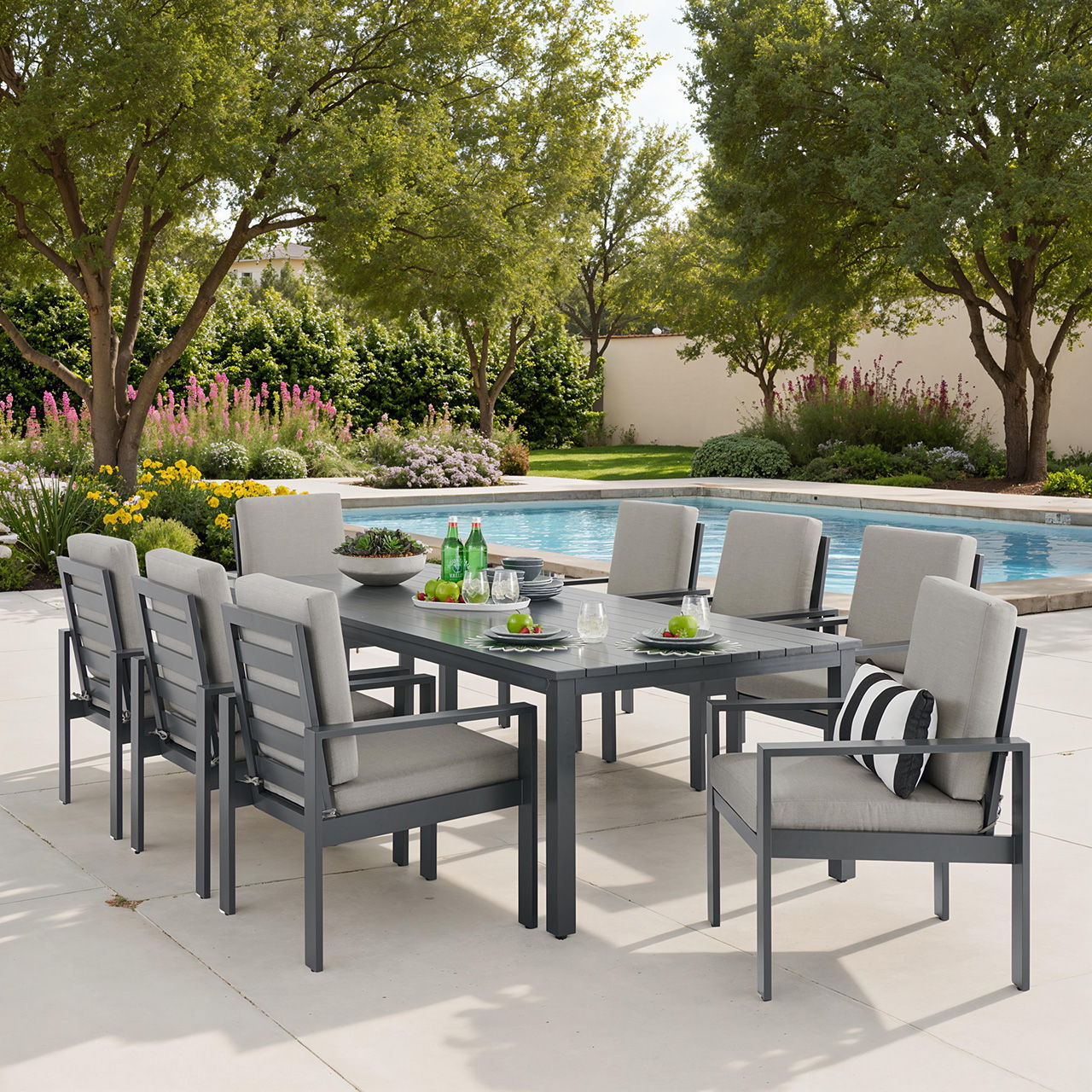 Outdoor dining set with chairs by a pool and surrounded by greenery.