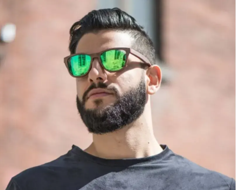 Homme portant des lunettes de soleil en bois avec verres verts