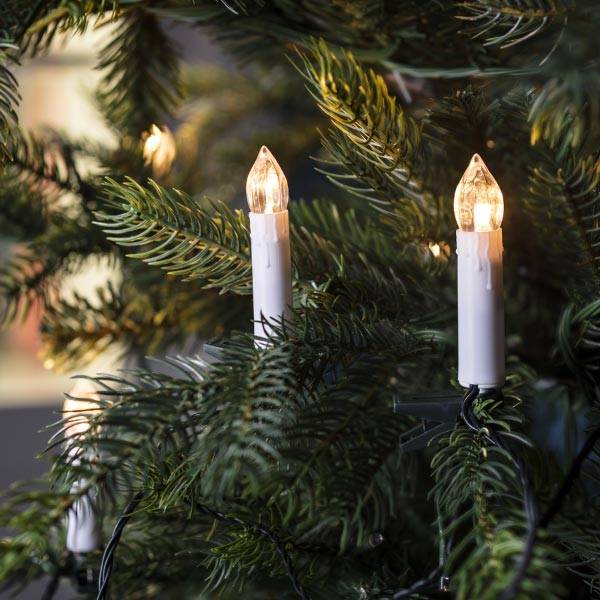 Candle light tree lights nestled in a Christmas tree.
