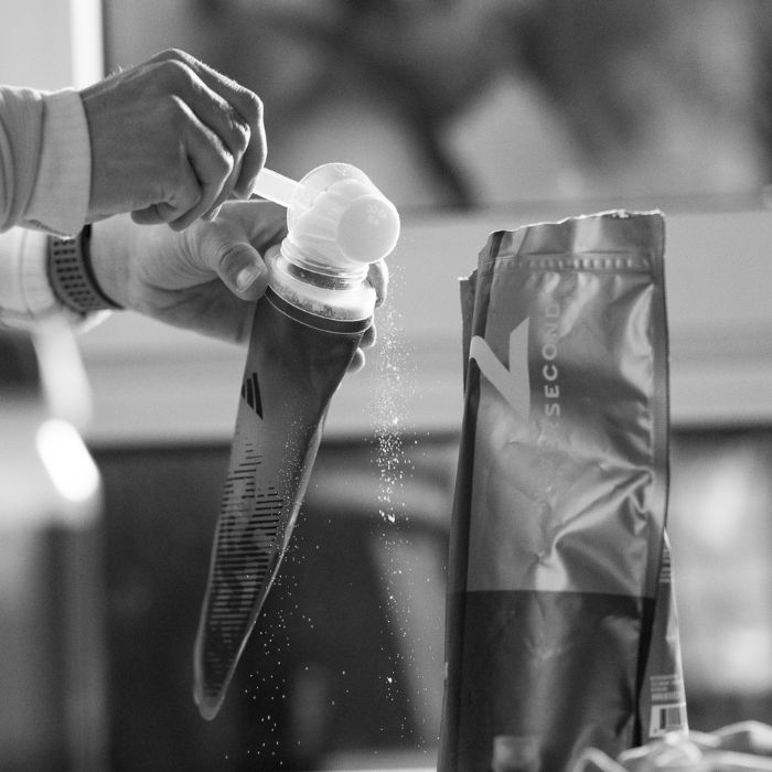 Ein Protein Pulver von der Marke Neversecond wird in eine Trinkflasche gefüllt.