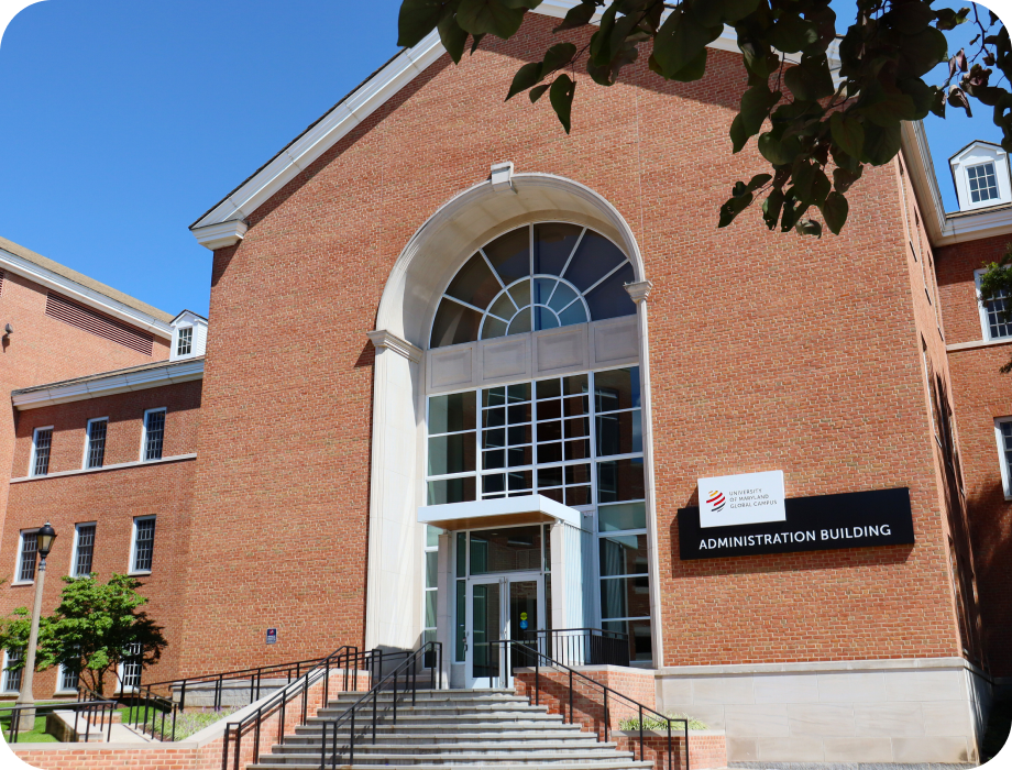 Brick administration building with large windows and entrance stairs.