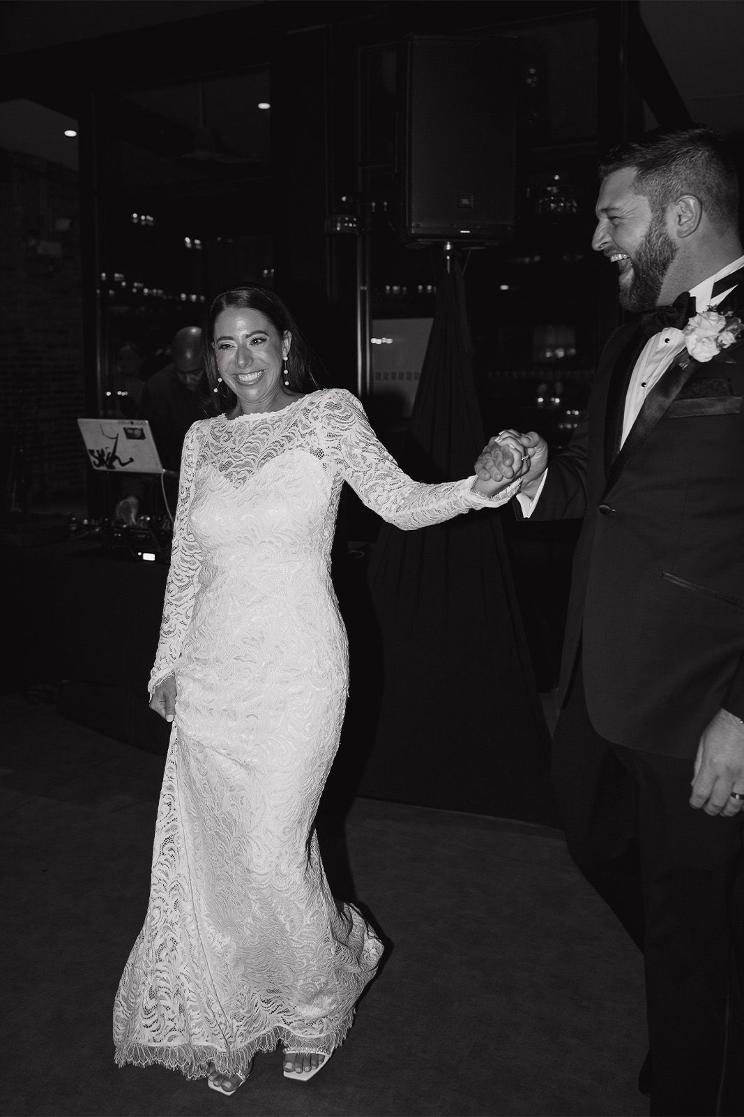 Couple dancing at a wedding, dressed elegantly in black and white attire.