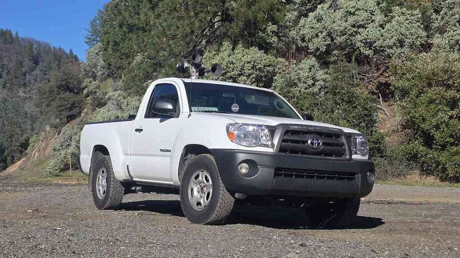 Front-three-quarter view Max's white 2009 Toyota Tacoma parked on gravel with Nathan AirChime P5 five-bell horn on cab roof gallery photo 2