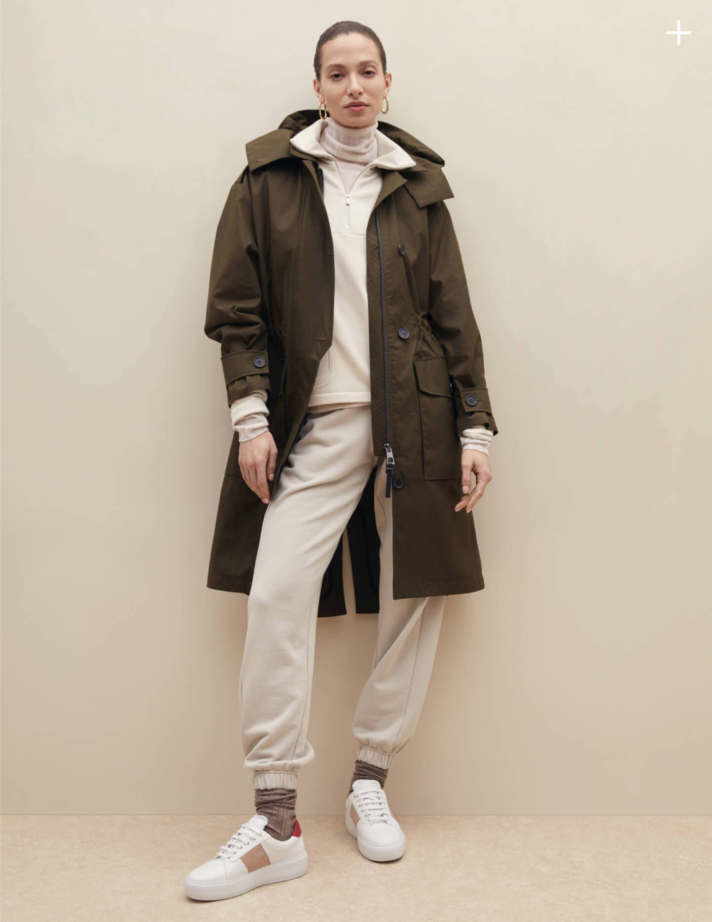 Woman wearing olive trench coat with beige monochrome outfit