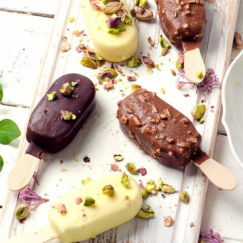 popsicles on tray covered with pistachios and chocolate