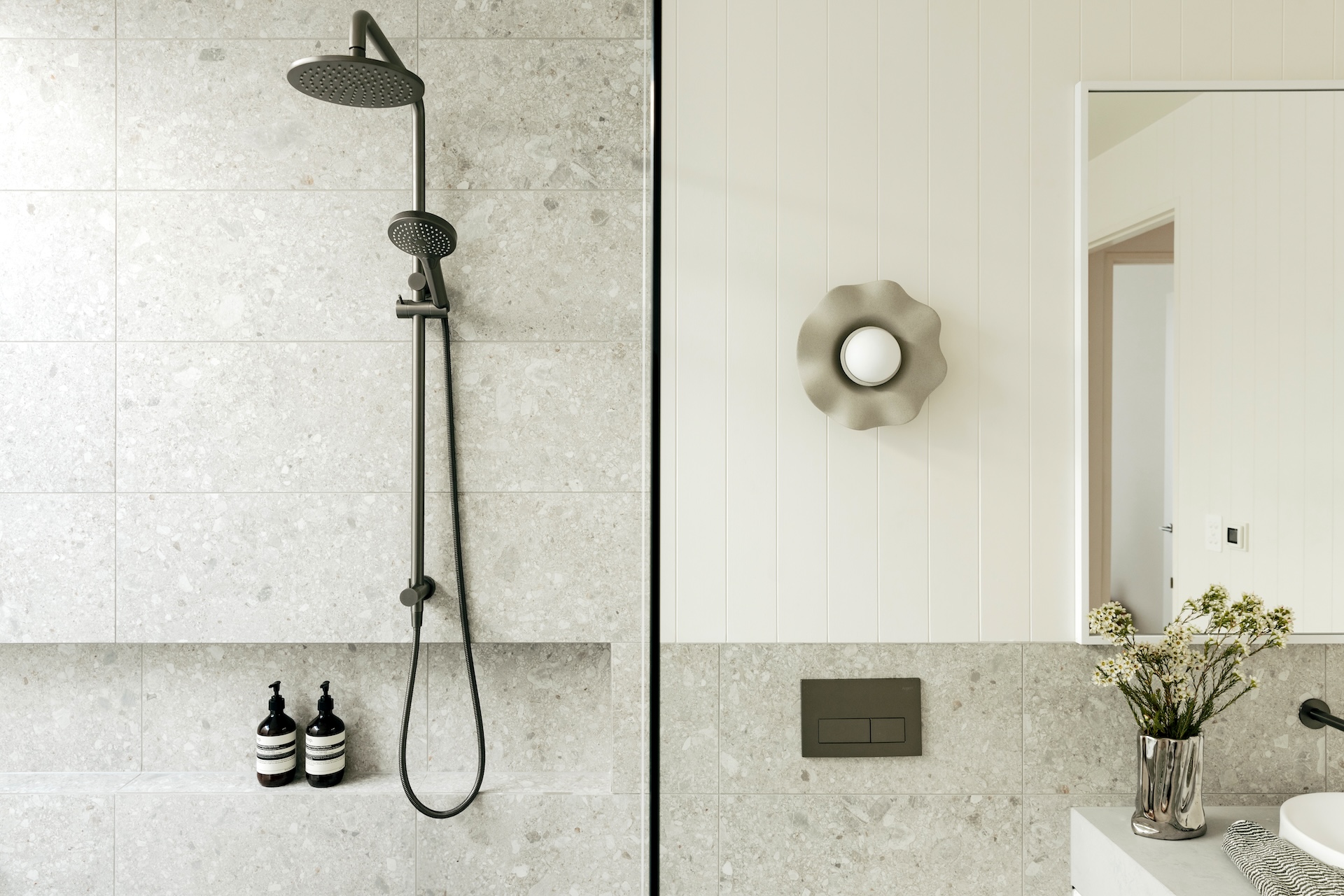 Modern bathroom with a shower and a decorative wall light