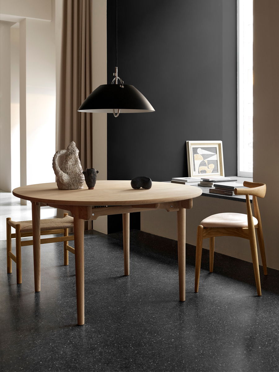 Modern Carl Hansen CH339 Dining Table Extendable dining area with a round table, chairs, and stylish lighting.