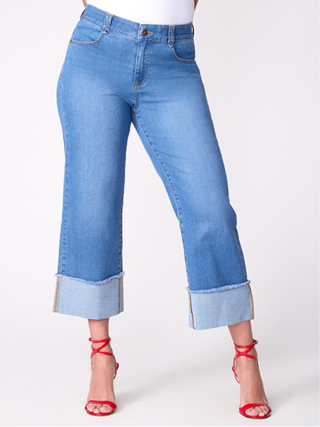 Model wearing light blue cropped jeans with rolled cuffs and red high heels.