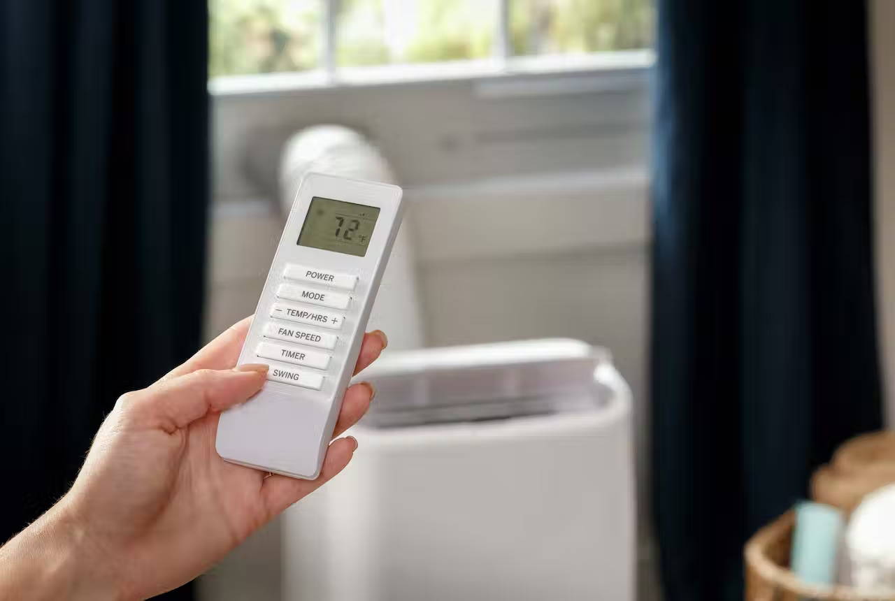 Person holding the remote control for the Haier Portable Air Conditioner