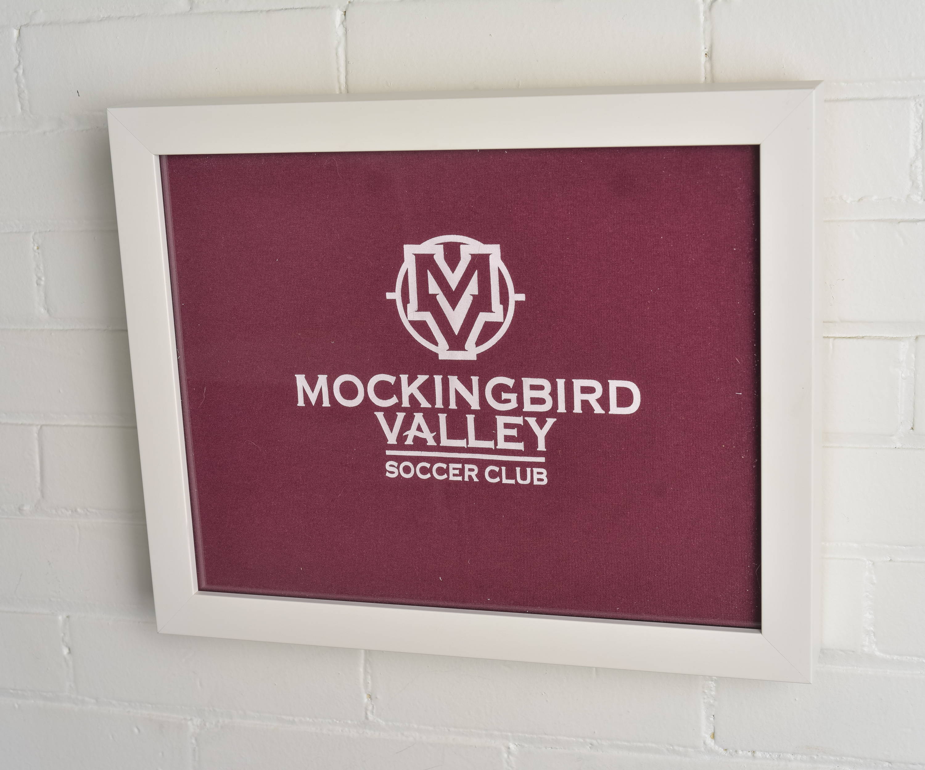Mockingbird Valley Soccer Club framed and displayed in a Shart Premium Square T-Shirt Frame Display Case - White