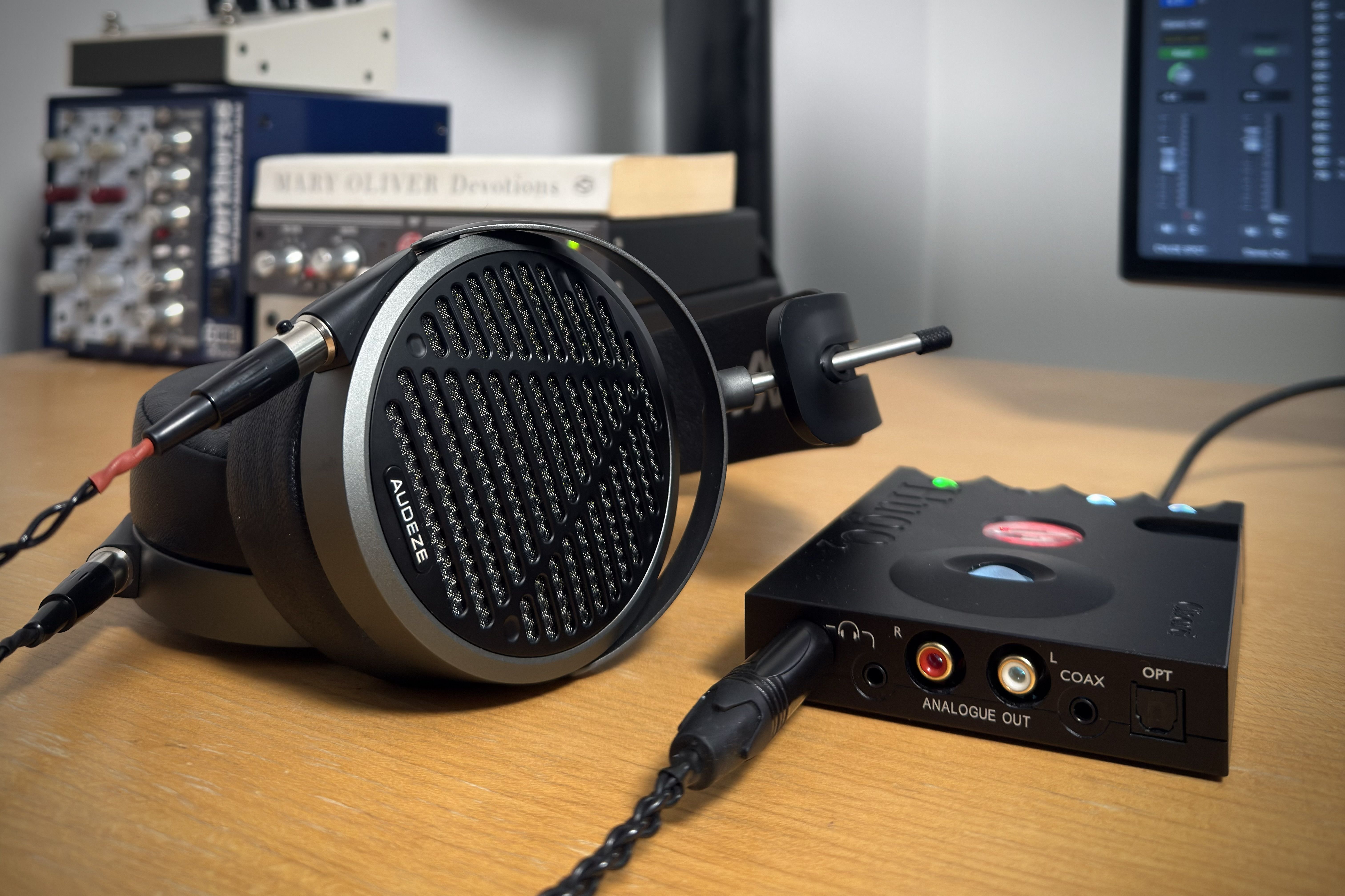 Audeze MM-500 Headphones next to an audio interface on a wooden desk.