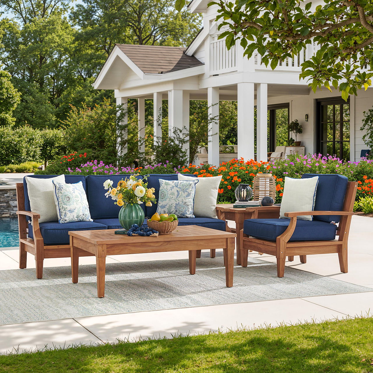 Outdoor seating area with wooden furniture and colorful cushions, surrounded by greenery.