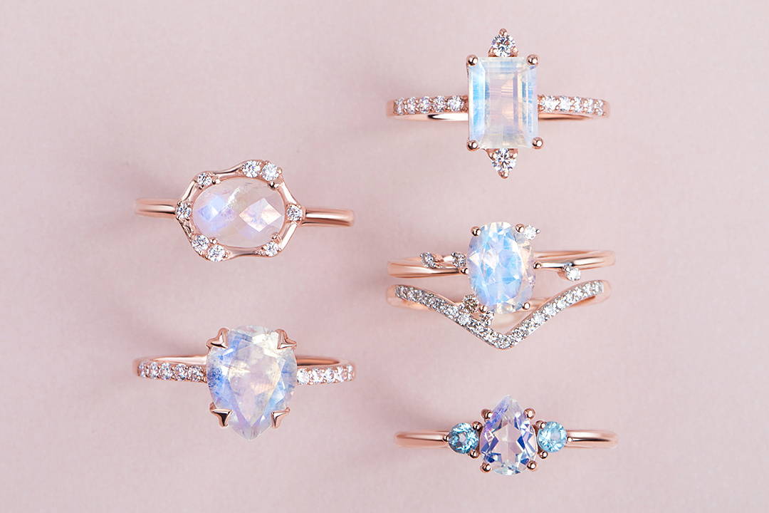 Five different Moonstone rings in different styles and one band ring are presented.