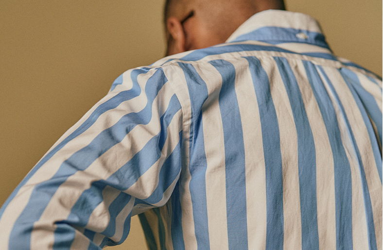 Person wearing a striped blue and white shirt, viewed from behind.