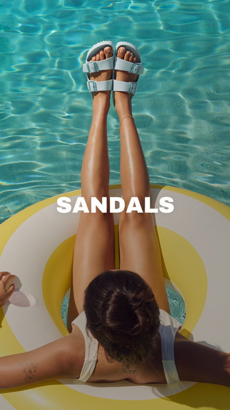 Person's legs in sandals resting on a float in a pool.