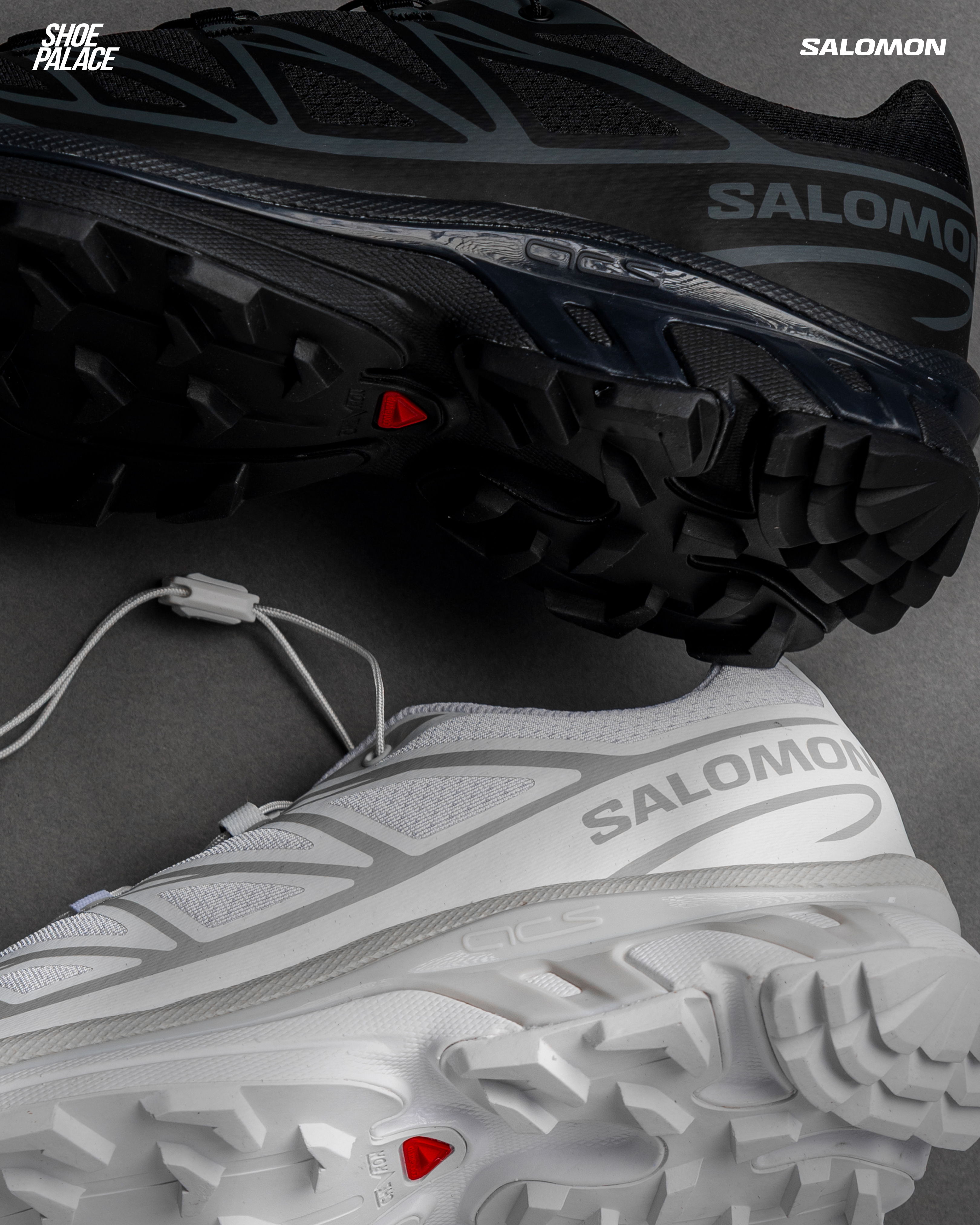 Black and white Salomon running shoes laid side by side.
