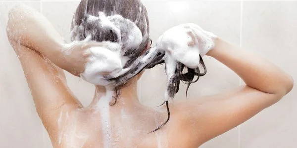 Kvinnan tvätter sit hår